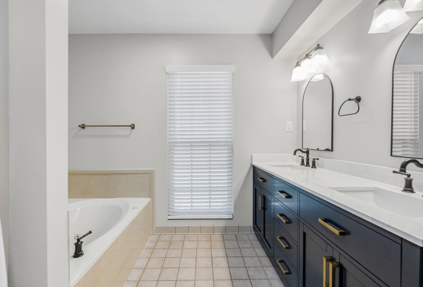Double vanity with dark cabinetry, white countertops, and black fixtures