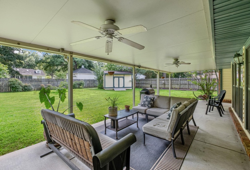 Expansive covered patio with multiple ceiling fans and a concrete surface