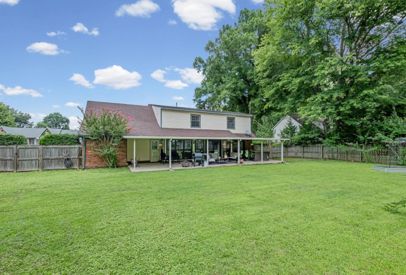 Expansive green lawn with a full wooden fence