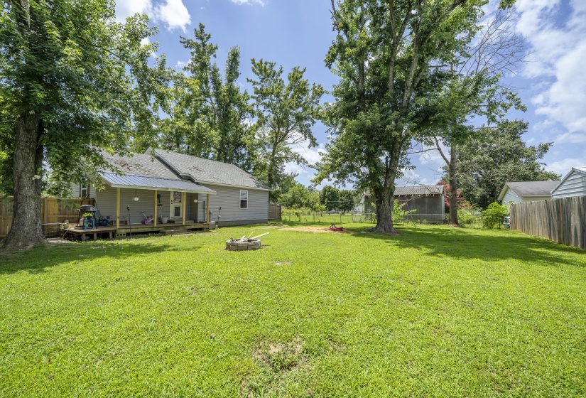 Expansive rear yard featuring a large grass lawn and mature trees