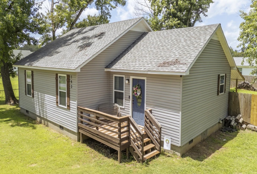 Light gray siding exterior with a blue entry door and white trim windows