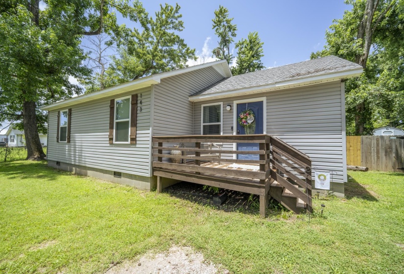 Light gray horizontal siding exterior with a dark blue entry door