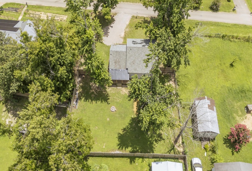 Aerial property overview featuring a main structure with a gray roof and an additional outbuilding with a metal roof