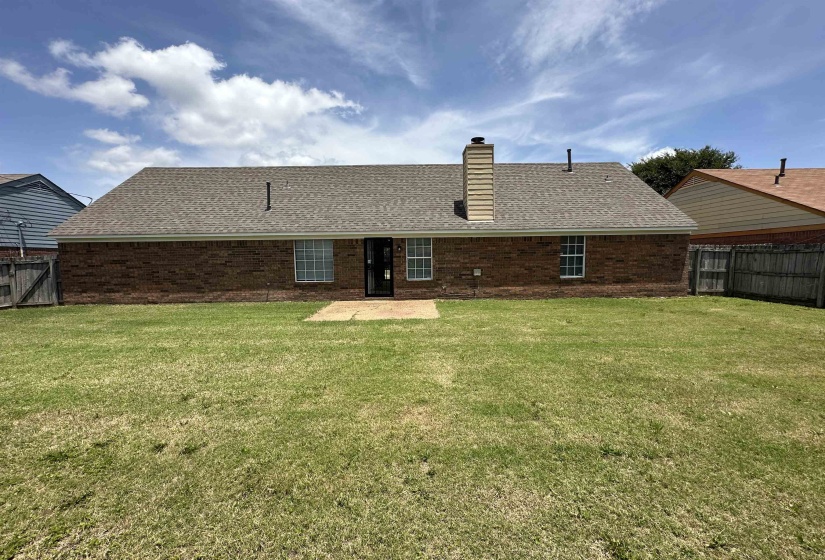 Rear exterior with brick facade and a shingled roof