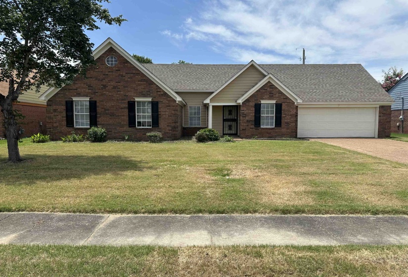 Brick and siding exterior featuring a prominent gable with an arched window