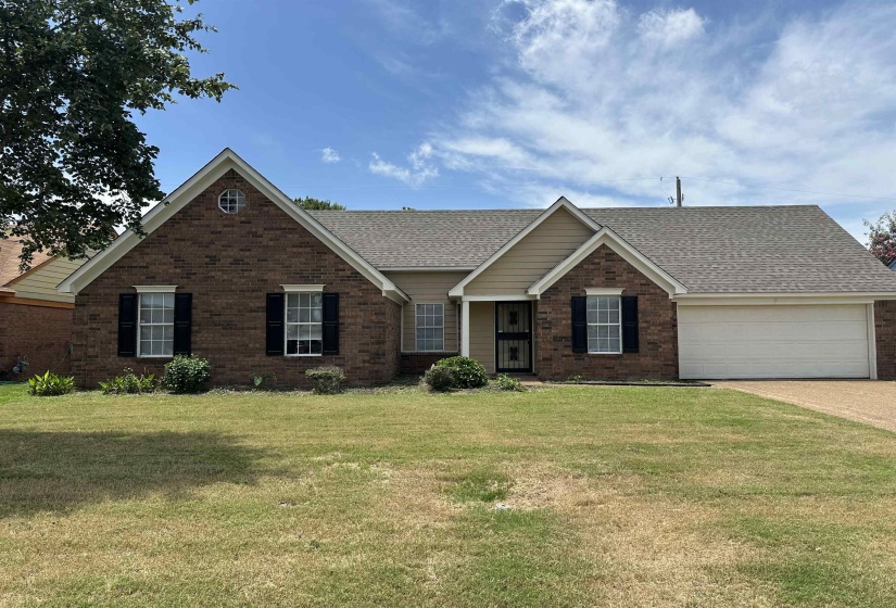 Brick exterior featuring a gabled roofline, a decorative circular window, and contrasting black louvered shutters