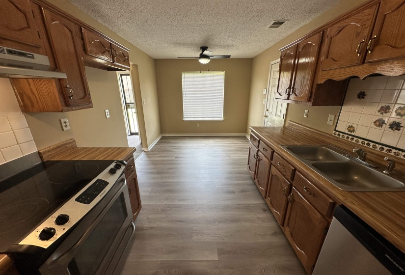 Kitchen with wood-finish flooring, wood cabinetry, and laminate countertops