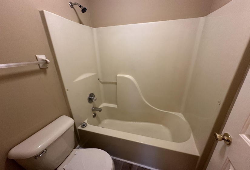 Integral shower-tub unit with a chrome shower head and faucet hardware