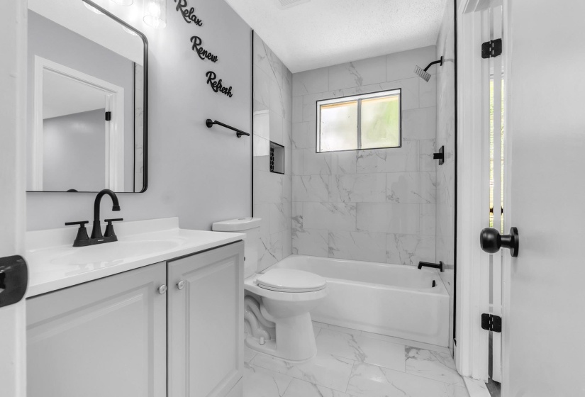 Bathroom featuring a single vanity with light gray cabinetry, a white countertop, and a black faucet