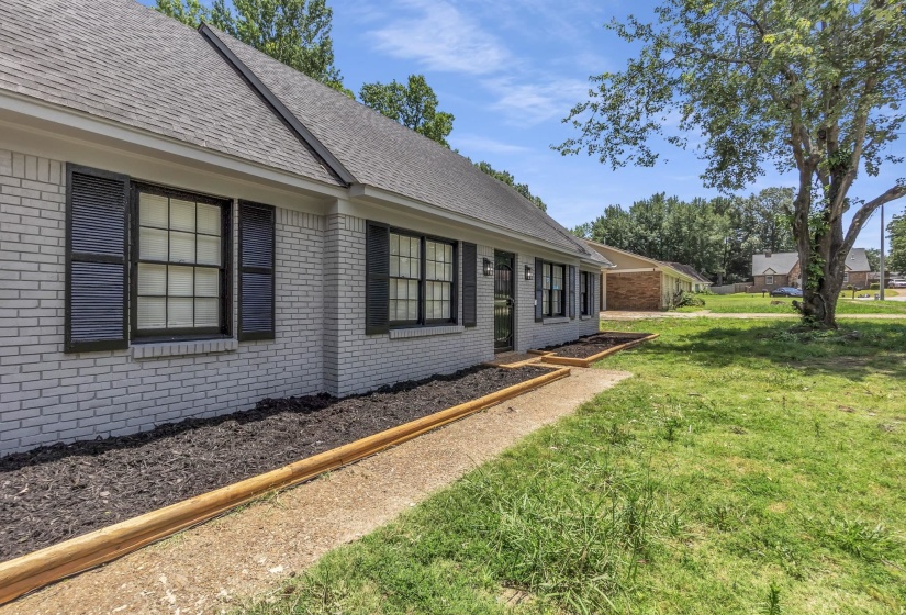 Brick exterior with a gray painted finish, dark shutters, and a gray shingle roof
