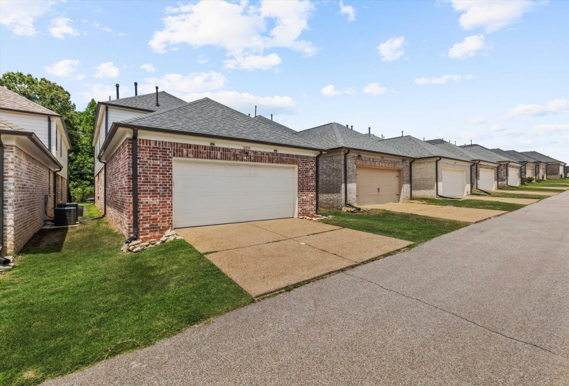 Brick facade garage with a white overhead door and concrete driveway