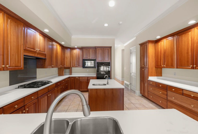 Kitchen featuring extensive wood cabinetry, light-toned countertops, and tile flooring