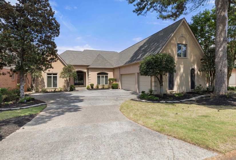 Stucco exterior residence featuring an arched portico entry and an attached two-car garage