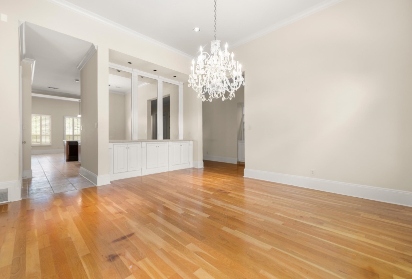 Hardwood flooring extends throughout this room, featuring a white chandelier