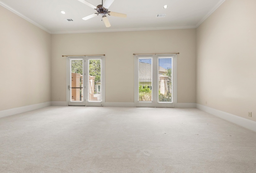 Spacious room featuring vaulted ceilings, crown molding, recessed lighting, and a ceiling fan