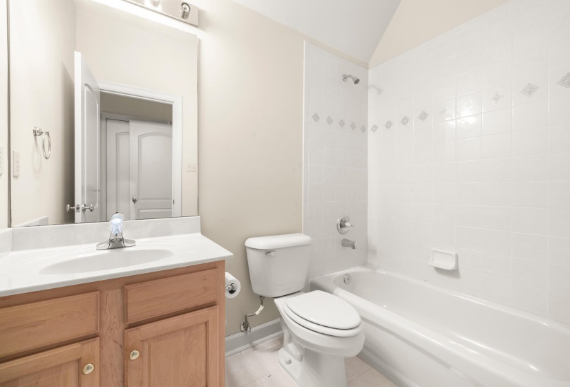 Full bathroom featuring a single vanity with wood cabinetry, a light-colored countertop, and a built-in sink