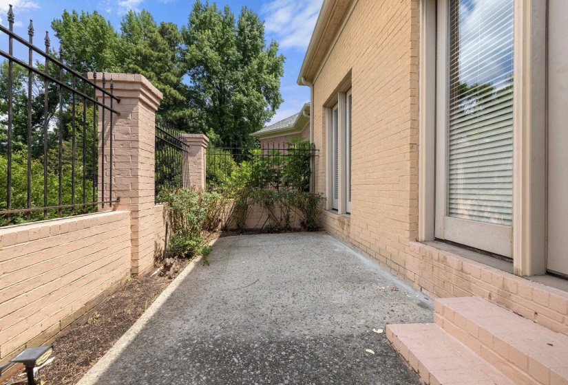 Exterior brick facade with a concrete patio