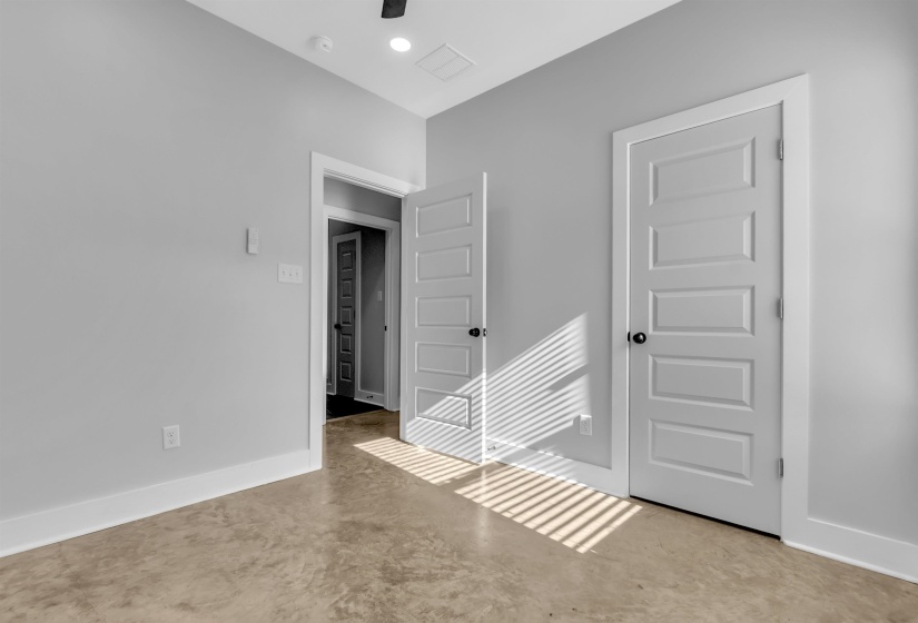 Neutral-toned room featuring a ceiling fan, recessed lighting, and durable concrete flooring