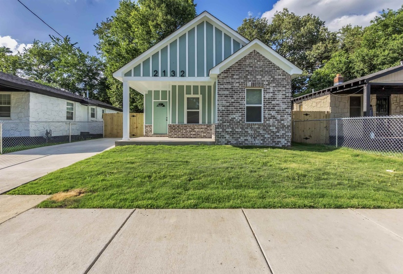 Contemporary cottage exterior with a covered front porch and brick accents