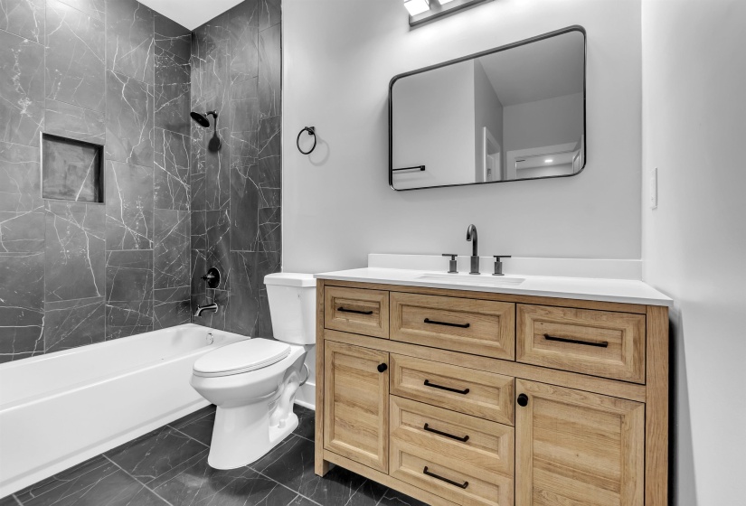 Bathroom featuring a light wood-finish vanity with a white countertop and rectangular undermount sink