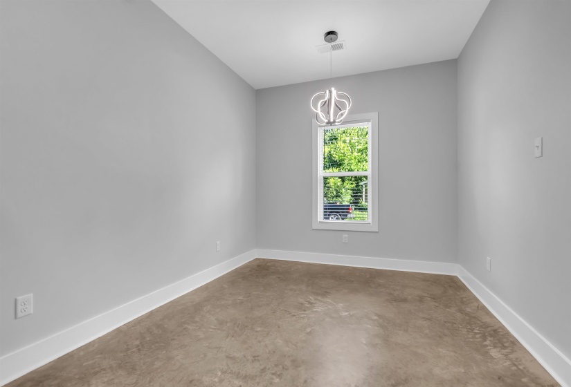 Room featuring neutral gray walls, a single window, and a contemporary chandelier