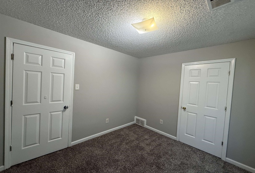 Neutral-toned walls complement the textured ceiling and dark carpet