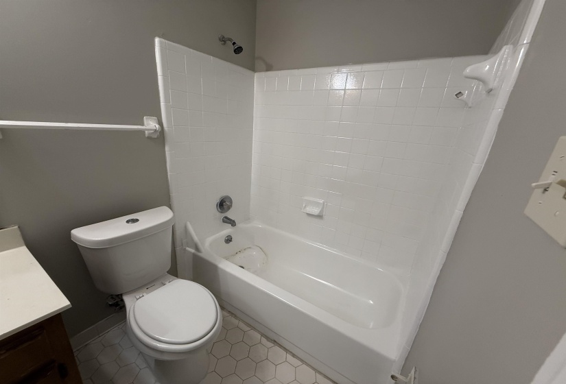 Bathroom featuring a white bathtub with subway tile surround and chrome fixtures
