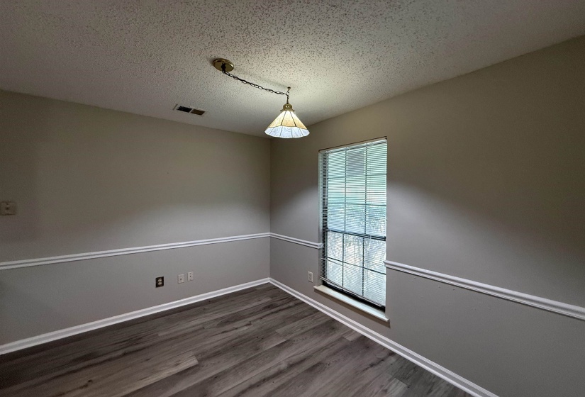 Interior space featuring wood-finish flooring, neutral paint palette, and decorative chair rail molding
