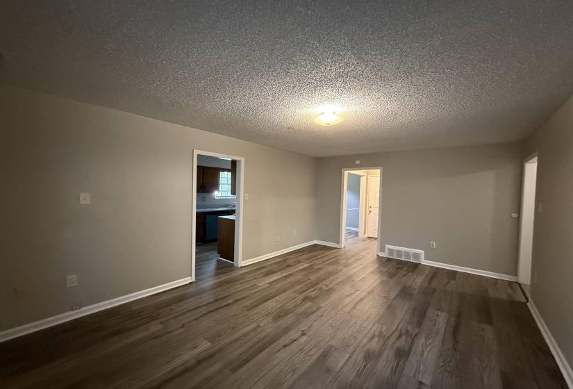 Interior space featuring wood-finish flooring, light neutral-toned walls, and white baseboards