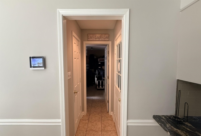 Hallway entry featuring tile flooring, white trim, and light gray wall paint
