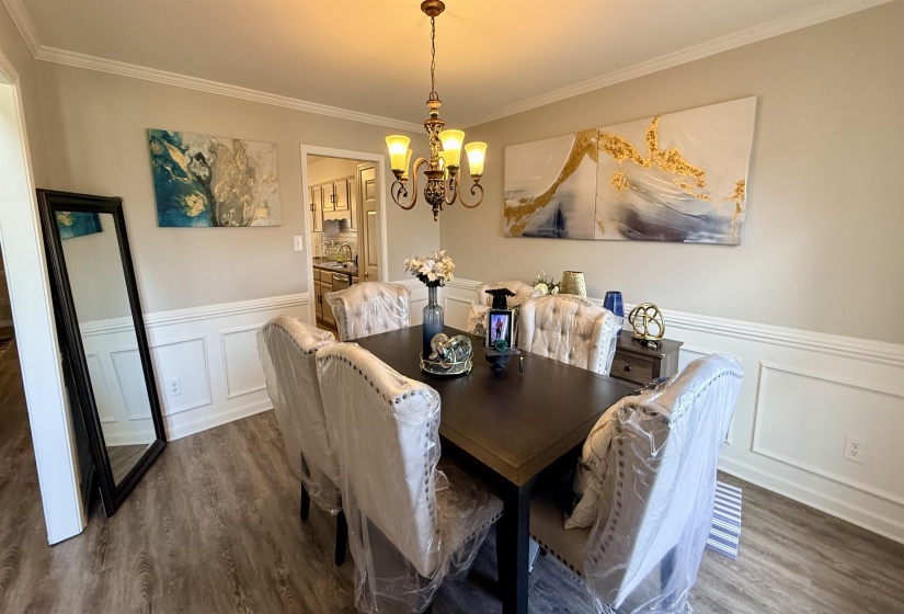 Dining area featuring wood-finish flooring and wainscoting