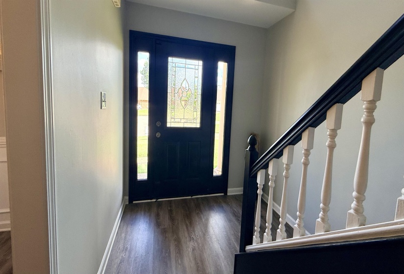 Entryway featuring a dark paneled front door with decorative glass inserts and side lights