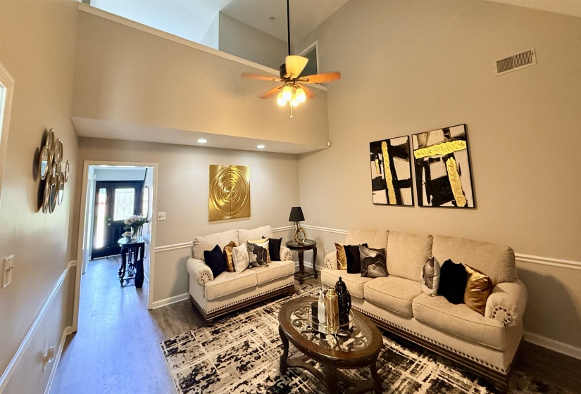 Spacious living area featuring vaulted ceilings, recessed lighting, and wood-finish flooring
