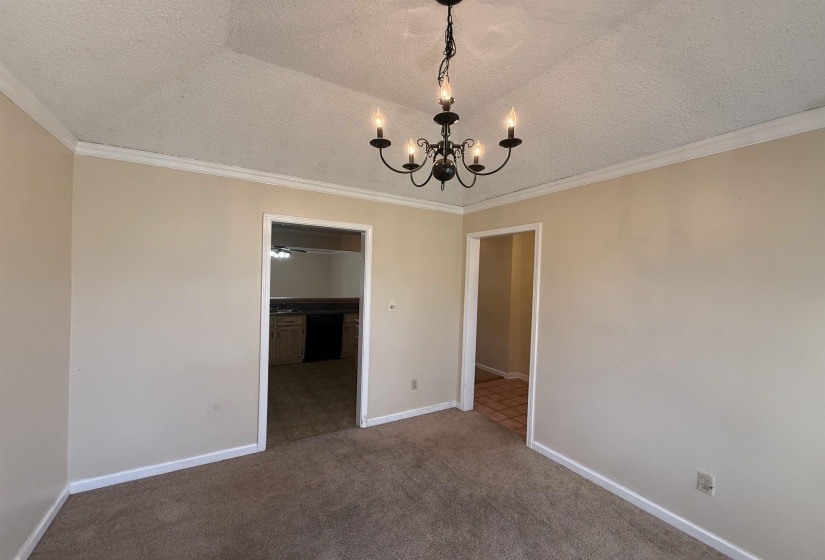 Interior room featuring a black wrought iron chandelier and neutral-toned carpet