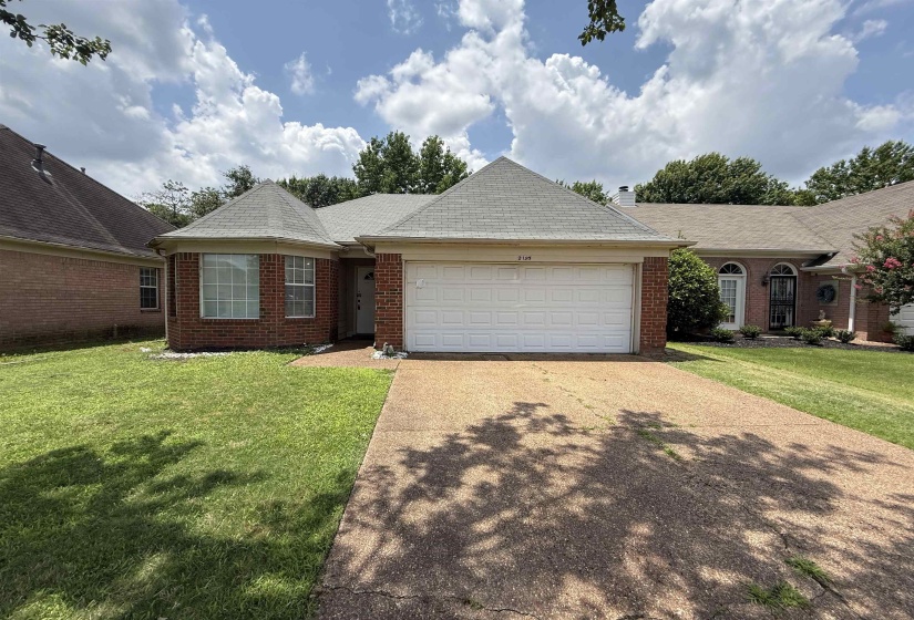 Brick exterior with a prominent two-car garage, bay window, and a gabled roofline