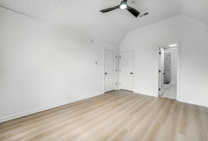 Room featuring wood-finish flooring, vaulted ceilings, and a modern ceiling fan
