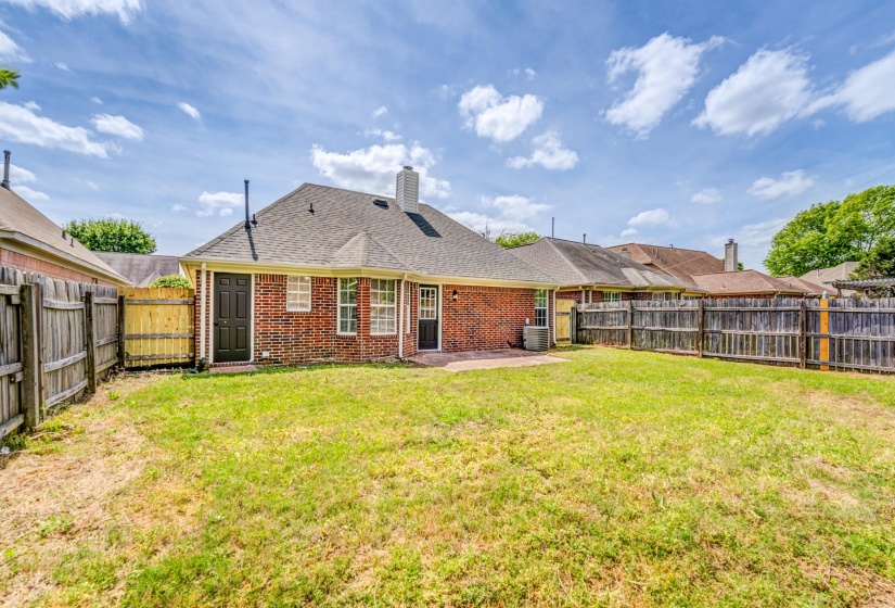 Brick exterior home featuring a rear patio with direct access to the expansive yard