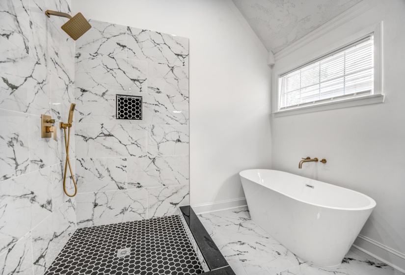 Spacious bathroom featuring a freestanding soaking tub, a walk-in shower with a gold-finish rainfall showerhead, and a matching handheld shower fixture