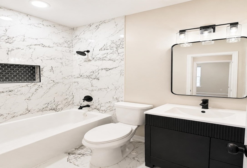 Contemporary bathroom featuring a black fluted vanity with a white rectangular sink, matte black hardware, and a black-framed mirror