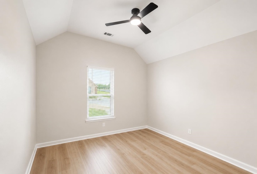 Room featuring a vaulted ceiling, wood-finish flooring, and a ceiling fan with light fixture