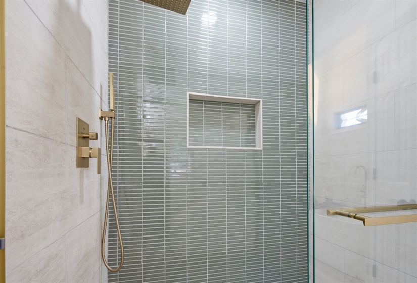 Walk-in shower with full glass enclosure, featuring a rain shower head and handheld spray