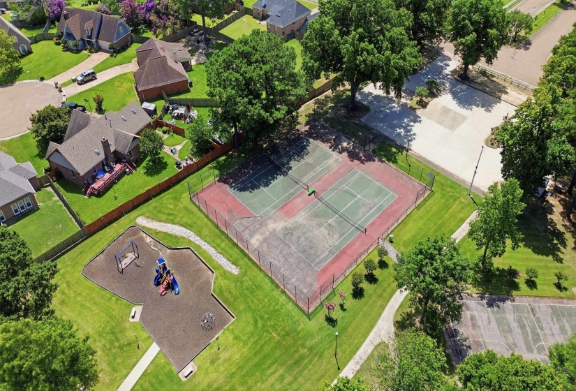 Community tennis courts and playground facilities bordered by residential properties