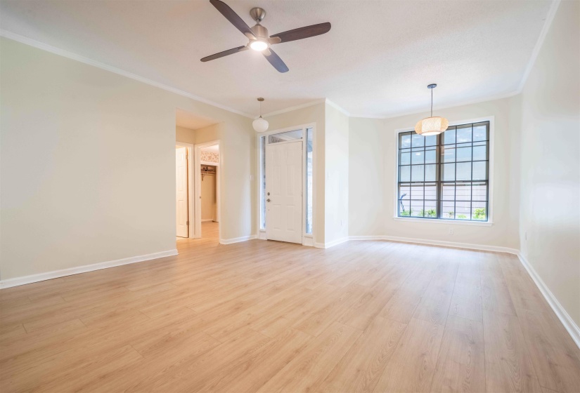 Spacious living area featuring light wood-finish flooring and neutral wall tones