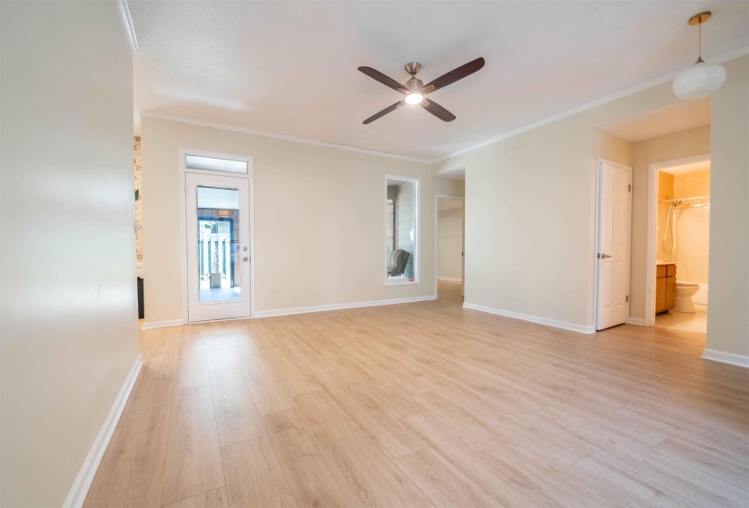 Spacious room featuring light wood-finish flooring, neutral wall paint, and white trim