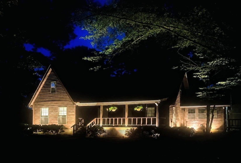 Wood-sided A-frame structure featuring a covered front porch with railings