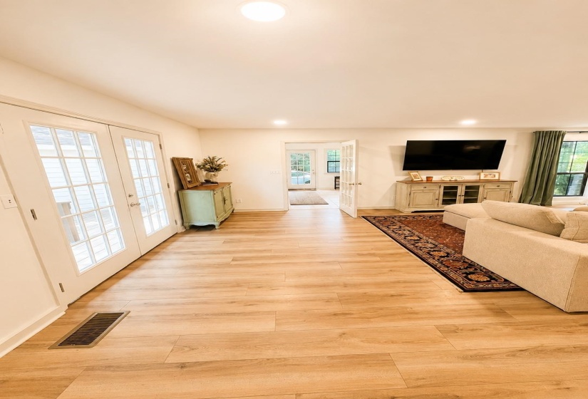 Open-concept living space featuring wood-finish flooring, recessed lighting, and white trim