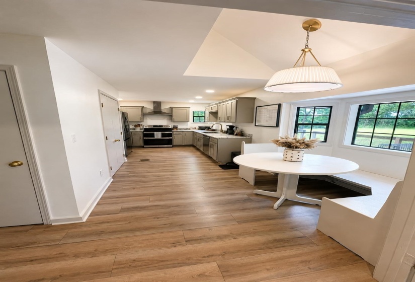 Kitchen featuring wood-finish flooring, recessed lighting, and a built-in banquette with window seating
