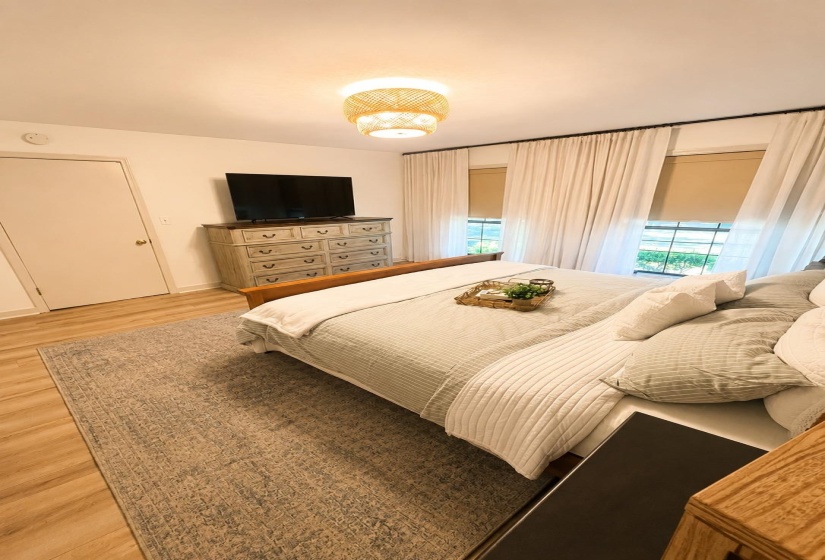 Room featuring wood-finish flooring and a central woven ceiling light fixture