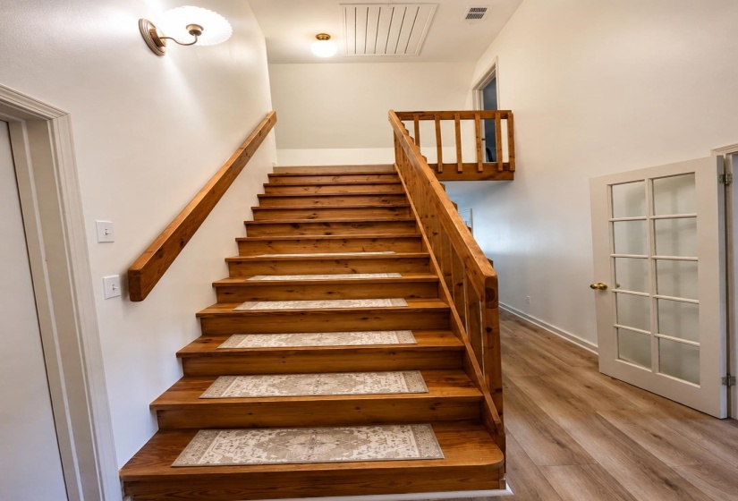 Warm wood staircase with matching wood handrails and balusters