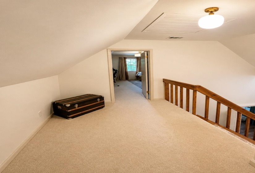 Upper-level hallway featuring neutral carpeting and white wall finishes